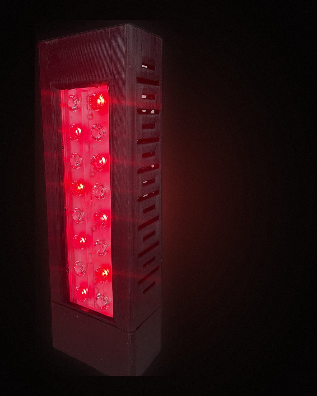 Panel NUMEN de luz roja encendido, mostrando las dos filas de LEDs y el disipador impreso en 3D